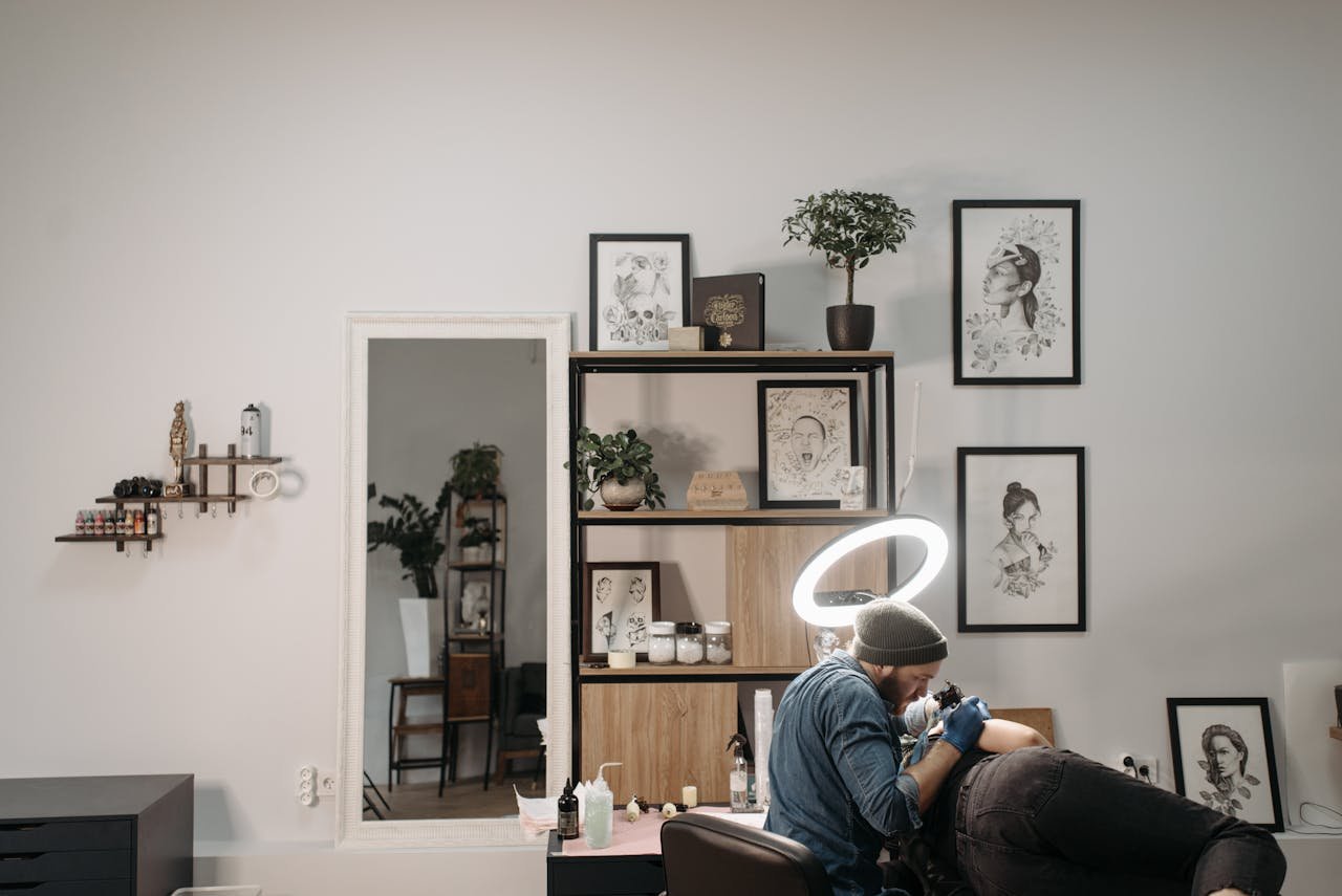 Tattoo artist working on client in a stylish and modern tattoo studio, focused and creative.